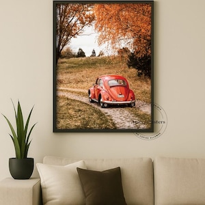 May include: A framed wall art print featuring a red vintage car parked on a dirt path surrounded by autumn trees with orange foliage. The print includes a circular watermark in the bottom right corner with the text Apexx Posters.
