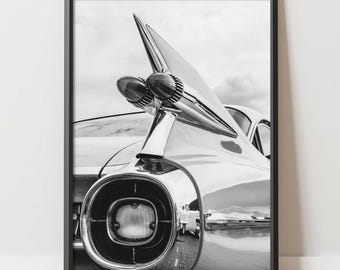 May include: Black and white framed print featuring a classic car's tail fin and rear light. The image highlights the chrome detailing and sleek design of the vintage vehicle. The print includes the text "APEXXPOSTERS" at the bottom.