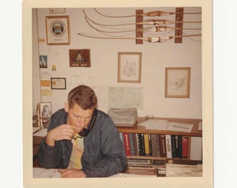 1960s Man in Office: Vintage Color Snapshot with Archery Display