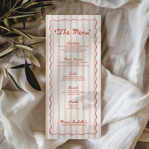 Può includere: Un biglietto del menu verticale con un design a righe crema e rosse. Il menu include sezioni per antipasti, portata principale, contorni, dessert e bevande. Il testo "The Menu" è in alto e "Maria Isabella's 20th Birthday" in basso.