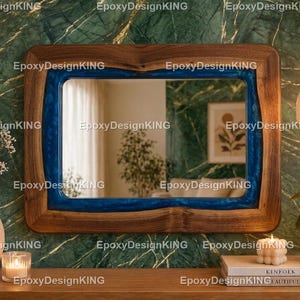 May include: A rectangular wooden mirror with a blue epoxy resin inlay. The mirror is framed in natural wood tones and is displayed on a wooden surface. Decorative items like a vase, candle, and books are also present.