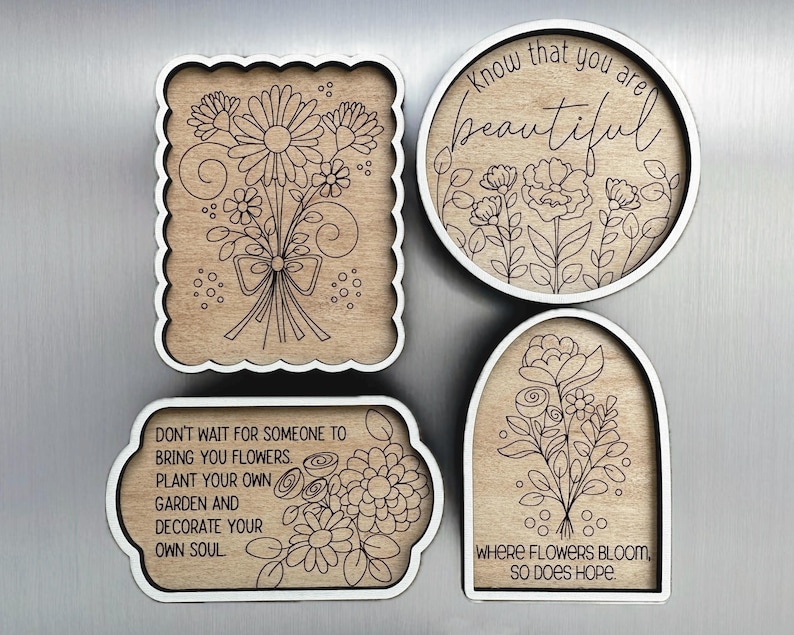 May include: Four wooden decorative pieces with white borders. Two feature floral designs, one with a bouquet and the other with a garden scene. The other two pieces have text: "Know that you are beautiful" and "Don't wait for someone to bring you flowers."