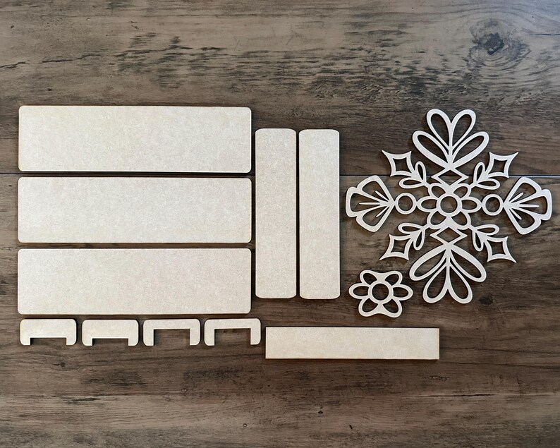 Puede incluir: Un conjunto de cinco piezas de madera sin terminar para manualidades. Las piezas incluyen cuatro formas rectangulares y un dise&ntilde;o de copo de nieve. Las piezas son perfectas para pintar, te&ntilde;ir o decoupage.