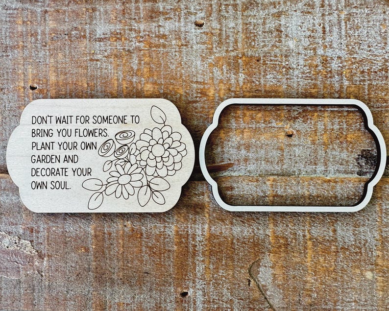 May include: Two wooden plaques with a floral design and text. One plaque has a floral design and the quote: "DON'T WAIT FOR SOMEONE TO BRING YOU FLOWERS. PLANT YOUR OWN GARDEN AND DECORATE YOUR OWN SOUL." The other plaque is a frame.