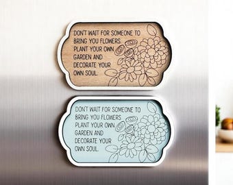 May include: Two decorative wooden signs with the quote "Don't wait for someone to bring you flowers, plant your own garden and decorate your own soul." One sign is light brown, the other is light blue, both with white borders and floral designs.