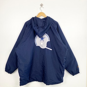 May include: A navy blue hooded jacket with a large white and gray football helmet logo on the back. The jacket is hanging on a wooden hanger against a white background. The jacket has long sleeves and a drawstring hood.