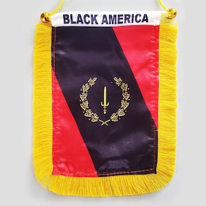 May include: A small, rectangular flag with the text "BLACK AMERICA" at the top. The flag features a black and red design with a gold emblem of a sword within a wreath. The edges are trimmed with yellow fringe.