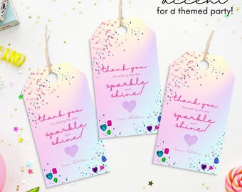 May include: Three pastel-colored gift tags with the text "thank you for making the day sparkle and shine!" and a heart. The tags have a glitter effect and are decorated with colorful gems. The text "perfect accent for a themed party!" is also visible.