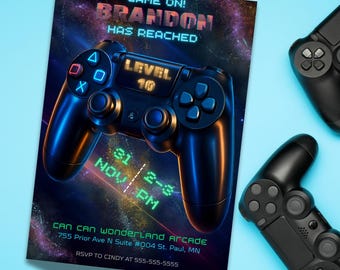 Puede incluir: Una invitación con temática de juegos con un gráfico de mando de juego negro. La invitación dice "GAME ON! BRANDON HAS REACHED LEVEL 10" con detalles del evento. Dos mandos de juego negros sobre un fondo azul claro.