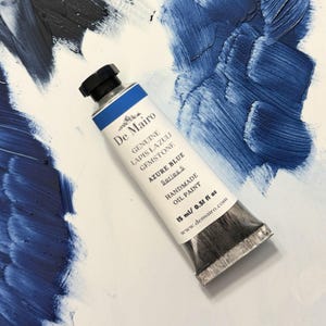 De Mairo Azure Blue oil paint tube beside sky blue paint swatch.