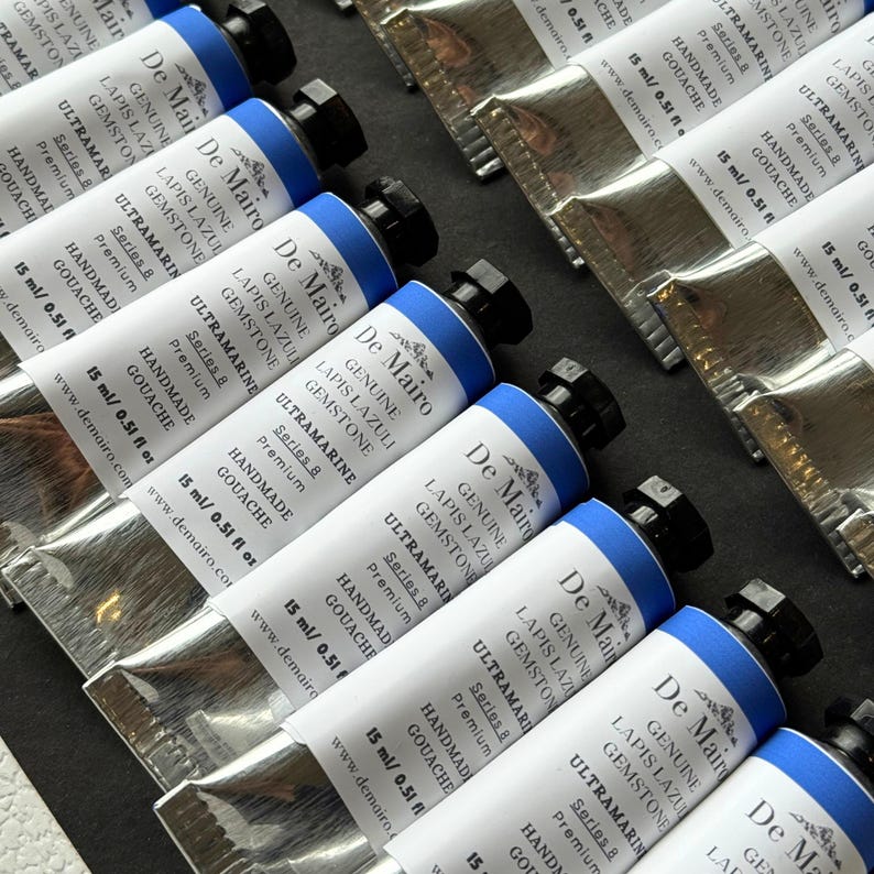 Multiple De Mairo gouache paint tubes arranged in tray showing handmade gemstone artist paint collection.