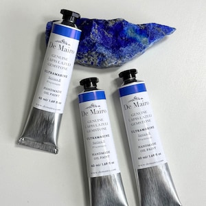 May include: Three tubes of De Mairo handmade oil paint, labeled "Genuine Lapis Lazuli Gemstone Ultramarine." Each tube is 40 ml / 1.69 fl oz. A piece of raw lapis lazuli gemstone is in the background.