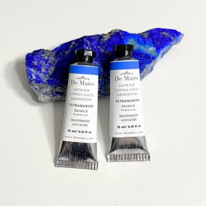 Two De Mairo lapis lazuli ultramarine blue gouache tubes with raw blue lapis lazuli mineral stone.