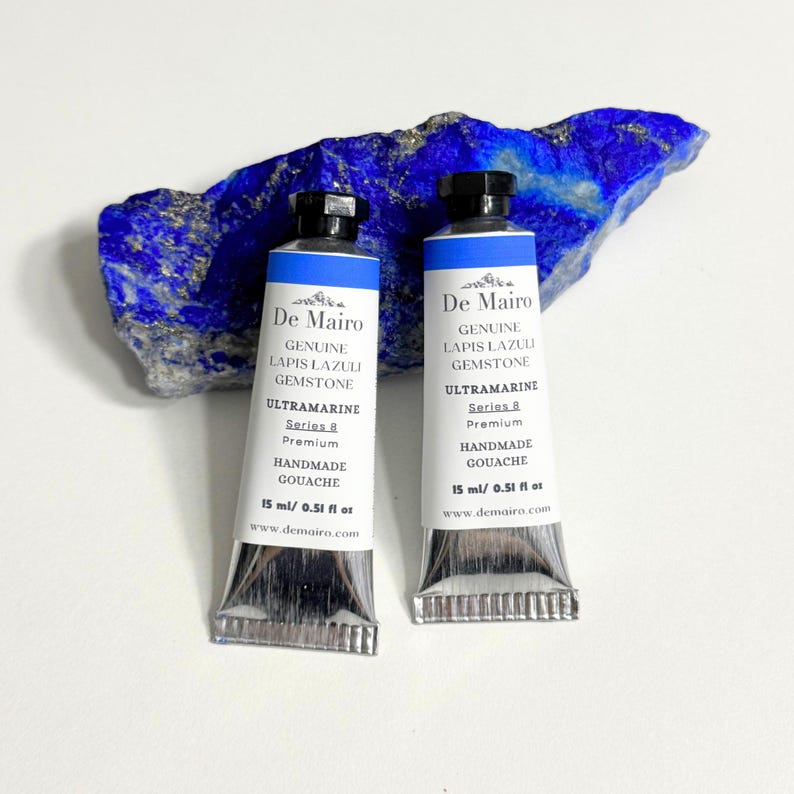 Two De Mairo lapis lazuli ultramarine blue gouache tubes with raw blue lapis lazuli mineral stone.