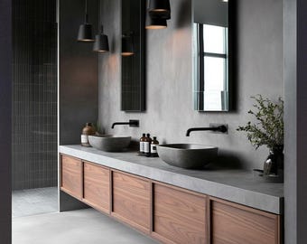May include: A double vanity bathroom featuring a concrete countertop with two gray stone vessel sinks, matte black wall-mounted faucets, and walnut wood cabinetry. The text reads: PERFECT FOR MODERN BATHROOMS WHERE FUNCTION MEETS MINIMALIST FORM.