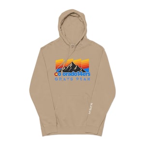 Puede incluir: Una sudadera con capucha de color beige con cordón y bolsillo de canguro. La parte delantera presenta un gráfico con el texto "Colorado 14ers" y "Grays Peak" en azul, naranja y amarillo. La manga tiene el texto "14,275 FT".