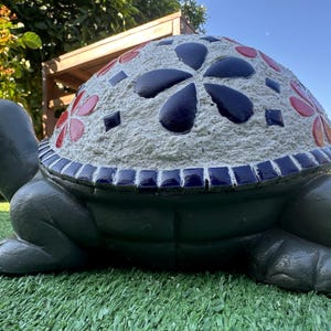 Handgemaakt en handgemaakt schildpadbeeld versierd met blauw/rode keramische tegels.