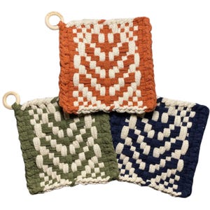 May include: Three woven pot holders in shades of orange, green, and navy blue, each with a geometric pattern and a wooden ring for hanging. The pot holders are square-shaped and appear to be made of a thick, textured material.
