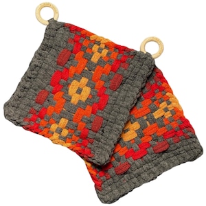 May include: Two square woven potholders featuring a geometric pattern in charcoal gray, bright orange, and red yarn. Each potholder includes a small, light-colored wooden ring attached to one corner, with the text friendly loom embossed on it.