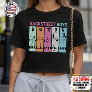 May include: Black crop top featuring the text "BACKSTREET BOYS" in a gradient font. Below the text are images of the band members with their signatures and the word "Millennium". A "Made in the USA" sticker is visible.