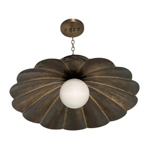 May include: A bronze-colored, shell-shaped pendant light fixture with a white globe light in the center. The fixture is suspended from a chain and a circular ceiling mount.