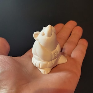 May include: White ceramic figurine of a mouse wearing a coat, looking up.