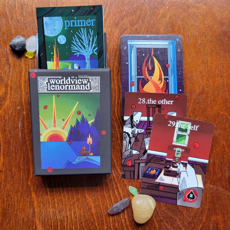 May include: A set of tarot cards with colorful illustrations and text. The cards are laid out on a wooden surface. The cards include "Primer", "28. The Other", and "29. The Self".