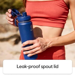 Pode incluir: Uma garrafa de &aacute;gua azul isolada com tampa de bico &agrave; prova de vazamentos. A garrafa &eacute; segurada por uma pessoa vestindo um suti&atilde; esportivo e leggings vermelhos. A garrafa tem uma al&ccedil;a e um logotipo. O texto "Leak-proof spout lid" est&aacute; na parte inferior.