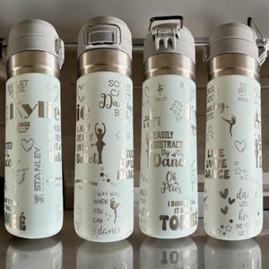 May include: Four pale green insulated water bottles with silver lids and ballet-themed text. The bottles feature phrases like "Sorry Can't Dancing Bye" and "Easily Distracted By Dance". Decorative hearts and stars are also included.