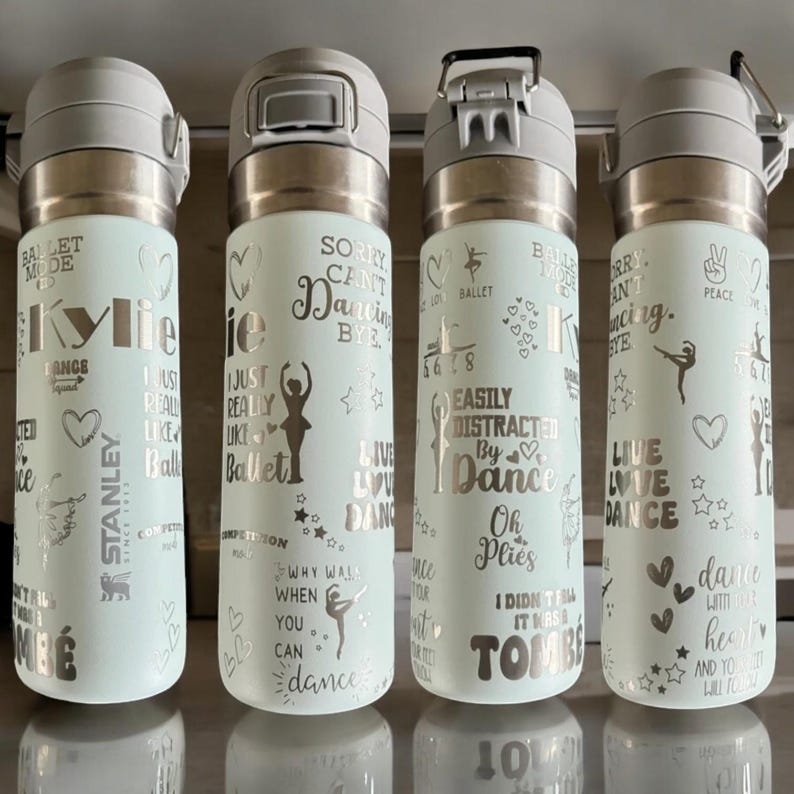 May include: Four pale green insulated water bottles with silver lids and ballet-themed text. The bottles feature phrases like "Sorry Can't Dancing Bye" and "Easily Distracted By Dance". Decorative hearts and stars are also included.