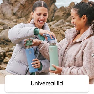 Pode incluir: Duas mulheres segurando garrafas de &aacute;gua azuis e verdes com tampas universais. As garrafas t&ecirc;m formato cil&iacute;ndrico e um logotipo. O texto da imagem diz "Universal lid".