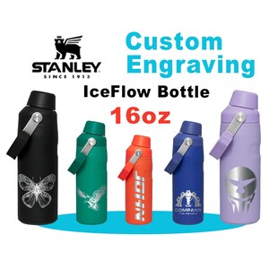 May include: A selection of Stanley IceFlow bottles in black, green, orange, blue, and purple. Each bottle has a handle and a design or text. The bottles are 473ml in size.
