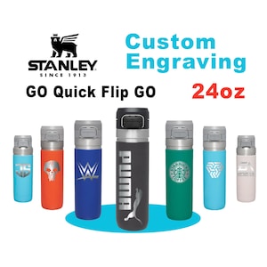 May include: A collection of Stanley GO Quick Flip GO water bottles, each with a unique design. The bottles are in various colors, including blue, orange, green, and black. The text "Custom Engraving" and "24oz" are also visible.