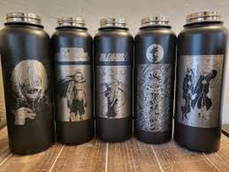 Pode incluir: Cinco garrafas de &aacute;gua pretas em a&ccedil;o inoxid&aacute;vel com tampas prateadas e desenhos de personagens de anime gravados. As garrafas s&atilde;o cil&iacute;ndricas e est&atilde;o sobre uma superf&iacute;cie de madeira. Cada garrafa apresenta uma ilustra&ccedil;&atilde;o de personagem diferente.