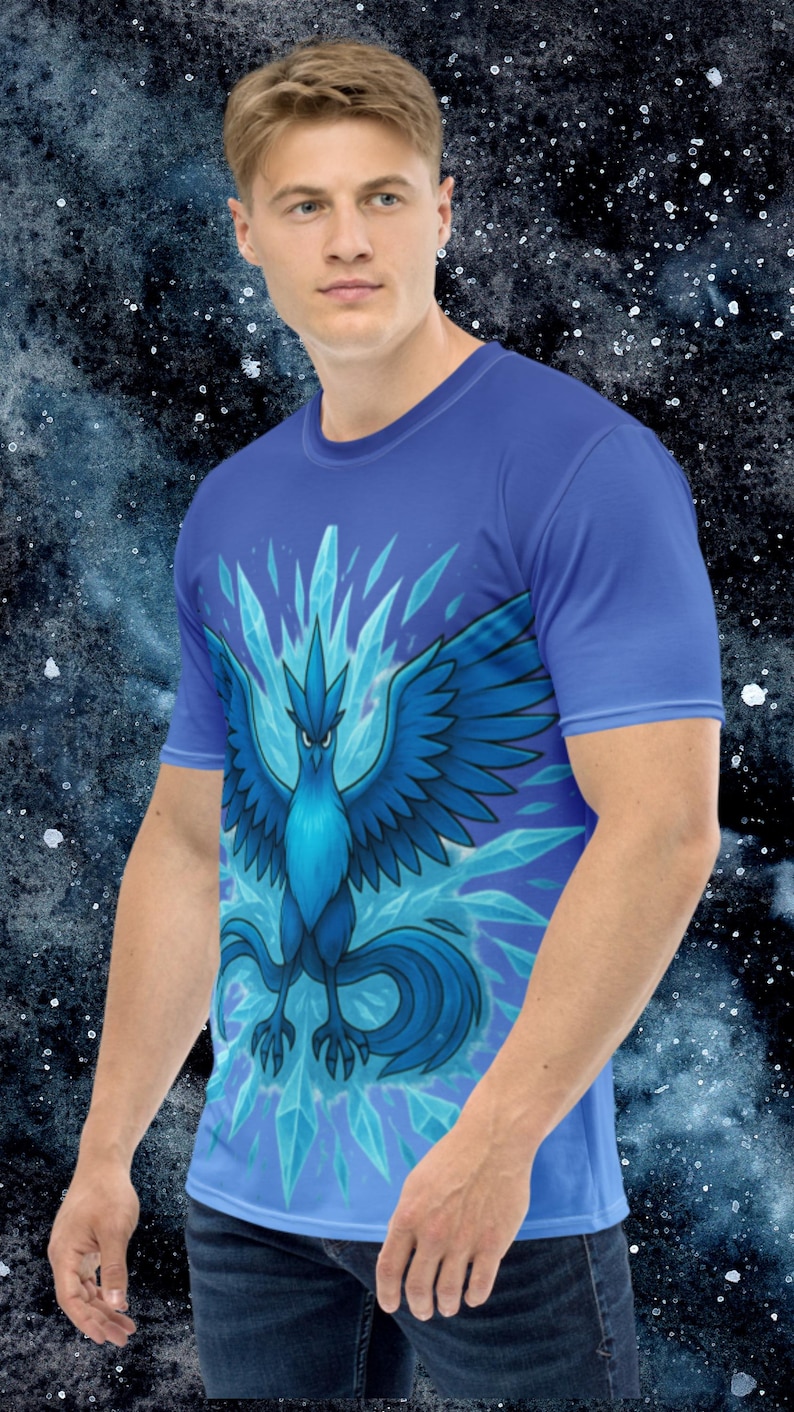 K&ouml;nnte beinhalten: Blaues T-Shirt mit einer stilisierten Illustration eines blauen Vogels mit ausgebreiteten Fl&uuml;geln und Eiskristallen. Der Vogel hat einen grimmigen Ausdruck. Das Shirt ist einfarbig blau und hat kurze &Auml;rmel.