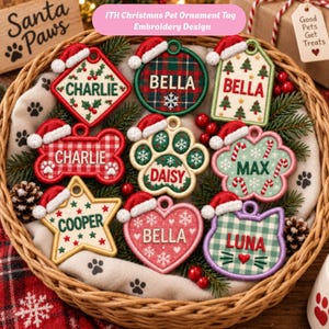 May include: A collection of nine embroidered pet ornament tags in a wicker basket, featuring various shapes like bones, hearts, stars, and paw prints. Each tag displays a name such as Charlie, Bella, Daisy, Max, Cooper, or Luna with festive holiday motifs.