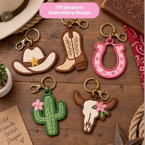 Puede incluir: Cinco llaveros bordados con motivos del oeste: un sombrero de vaquero beige con una estrella dorada, una bota de vaquero marrón claro, una herradura rosa con detalles florales, un cactus verde con una flor rosa y un cráneo de toro blanco.