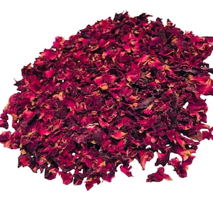 May include: A pile of dried rose petals, predominantly deep red with hints of yellow and brown. The petals are irregularly shaped and appear to be naturally dried, suitable for potpourri, crafts, or other decorative uses.