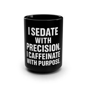 May include: Black ceramic mug with white text that reads: "I SEDATE WITH PRECISION. I CAFFEINATE WITH PURPOSE." The mug is cylindrical and has a glossy finish. The text is in a bold, sans-serif font.