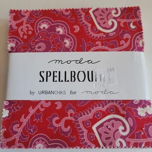 May include: A red fabric square with a pink and white paisley pattern. The fabric is labeled "moda SPELLBOUND by URBANCHIKS for moda 180"