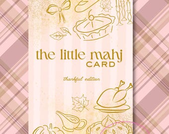 Op de afbeelding: Een verticale kaart met een roze en gouden Thanksgiving-thema. De kaart bevat lijntekeningen van een strik, brood, kaarsen, taart, bladeren, een kalkoen, een juskom en een pompoen. De tekst "the little mahj CARD thankful edition" is in goud weergegeven.