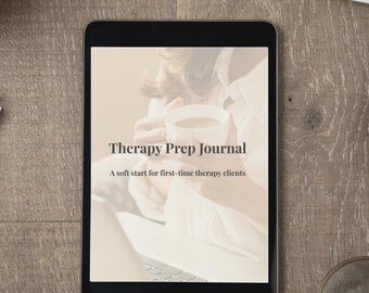 May include: A black tablet displaying the text "Therapy Prep Journal" and "A soft start for first-time therapy clients." The tablet is on a wooden surface, with a keyboard, phone, and magnifying glass in the background.