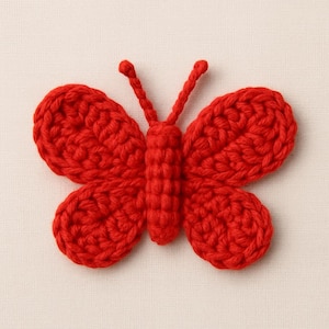 May include: A vibrant red crochet butterfly with detailed wings and antennae. The handmade butterfly is a decorative item, possibly for crafts or embellishments. The bright color and textured yarn create a visually appealing design.
