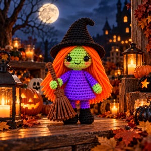 Könnte beinhalten: Eine gehäkelte Hexenpuppe mit leuchtend orangefarbenem Wollhaar, einem schwarzen spitzen Hut und einem violetten Kleid. Die Puppe hat hellgrüne Haut, große schwarze Augen und hält einen braunen Wollbesen. Sie steht auf einer Holzoberfläche.