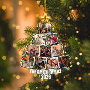 May include: A Christmas tree-shaped ornament featuring ten individual family photo frames arranged in a tiered design. The ornament is topped with a gold star, decorated with colorful string lights, and displays the text THE SMITH FAMILY 2026.