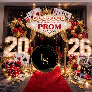 May include: A casino-themed prom backdrop with a red carpet, playing cards, dice, and balloons. The sign reads "Welcome to Fabulous Prom 2026". The numbers "20" and "26" are illuminated with lights.