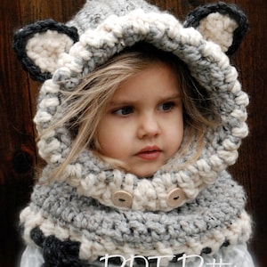 May include: A grey and white crocheted hooded scarf with ear flaps and two wooden buttons. The scarf is worn by a young child. The text "PDF Pattern" is visible at the bottom of the image.