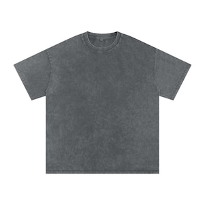 May include: A washed charcoal grey t-shirt with a crew neck and short sleeves. The shirt has a slightly textured, vintage appearance. The fabric appears soft and comfortable, suitable for casual wear.