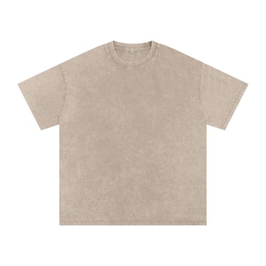 Puede incluir: Una camiseta de gran tamaño, lavada a la piedra, en color beige neutro. La camiseta tiene cuello redondo clásico y mangas cortas. La tela tiene un aspecto texturizado y vintage.
