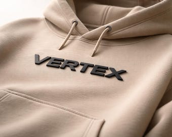May include: A tan hoodie with a drawstring hood and a front pocket. The word "VERTEX" is displayed in bold, black letters across the chest. The hoodie is made of a soft, comfortable material.